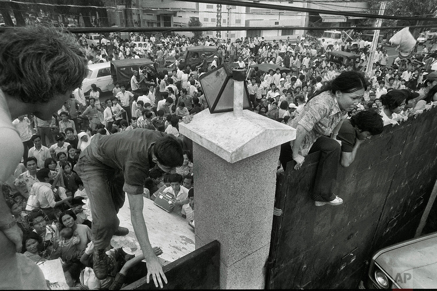  South Vietnamese civilians scale the 14-foot wall of the U.S. embassy in Saigon, trying to reach evacuation helicopters as the last Americans depart from Vietnam, April 29, 1975. (AP Photo) 