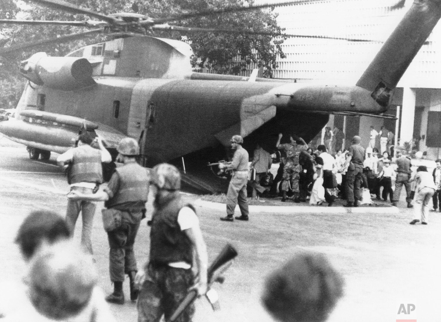  U.S. Marines disembark from a CH-53 "Jolly Green Giant" to restore order and restrain crowds at the gates of the U.S. Embassy in Saigon during the final evacuation on April 29, 1975. (AP Photo/Frances Starner) 