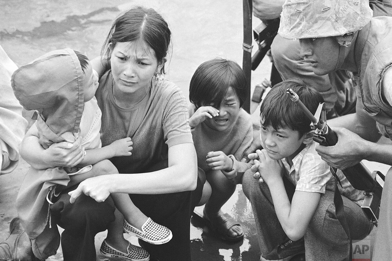  A weeping South Vietnamese mother and her three children are shown on the deck of this amphibious command ship being plucked out of Saigon by U.S. Marine helicopters in Vietnam, April 29, 1975. (AP Photo/J.T. Wolkerstorfer) 