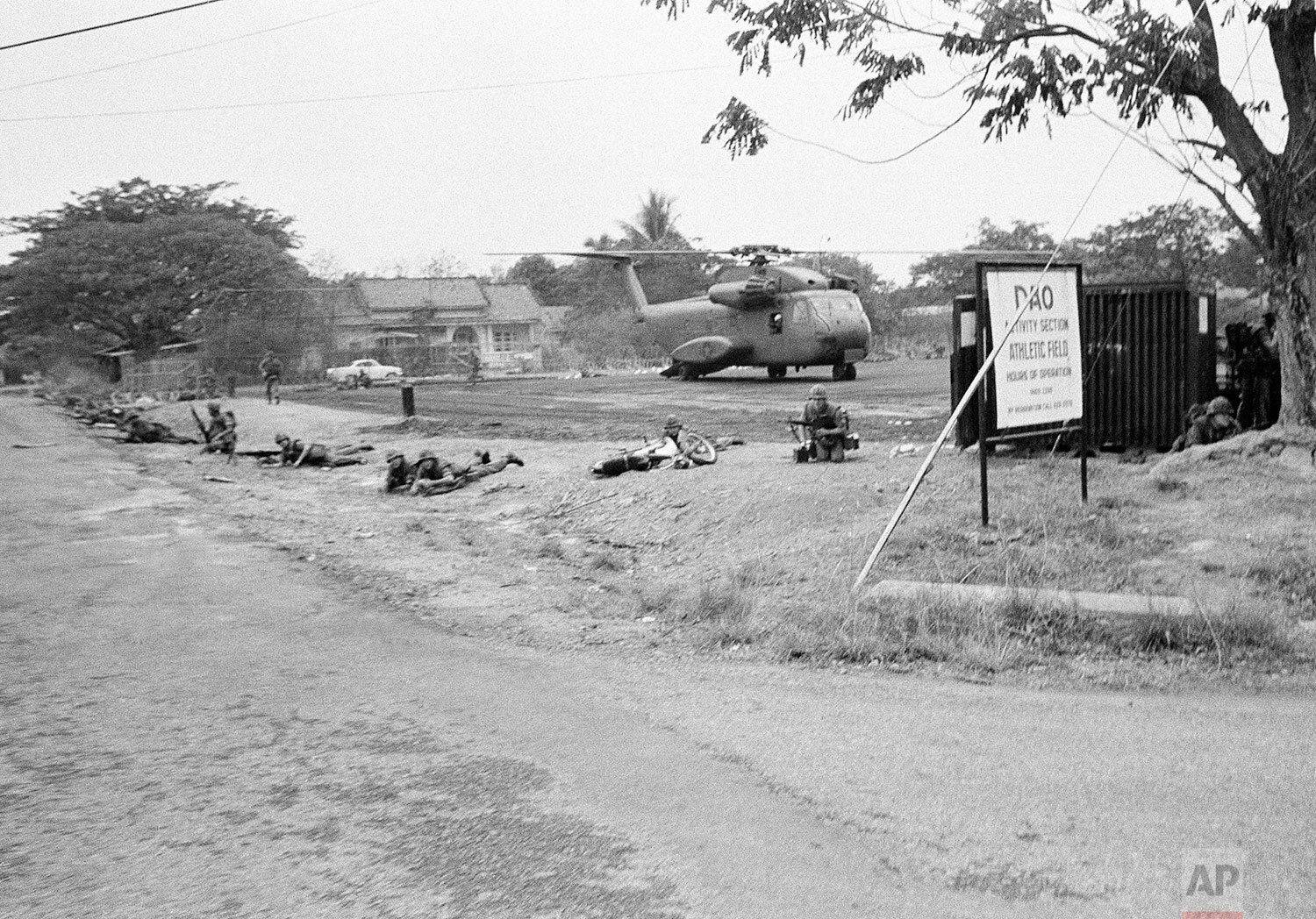  U.S. Marines drop to prone firing position to guard helicopter at landing zone at former U.S. Military headquarters at Tan Son Nhut airport during evacuation from Saigon on April 29, 1975. (AP Photo) 