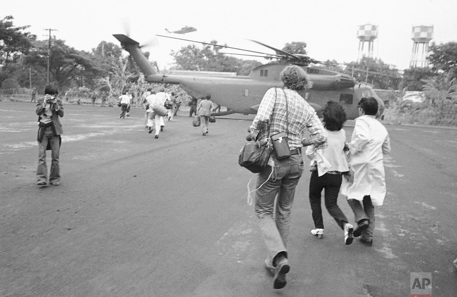  Americans and Vietnamese run for a U.S. Marine helicopter in Saigon during the evacuation of the city, April 29, 1975. (AP Photo) 