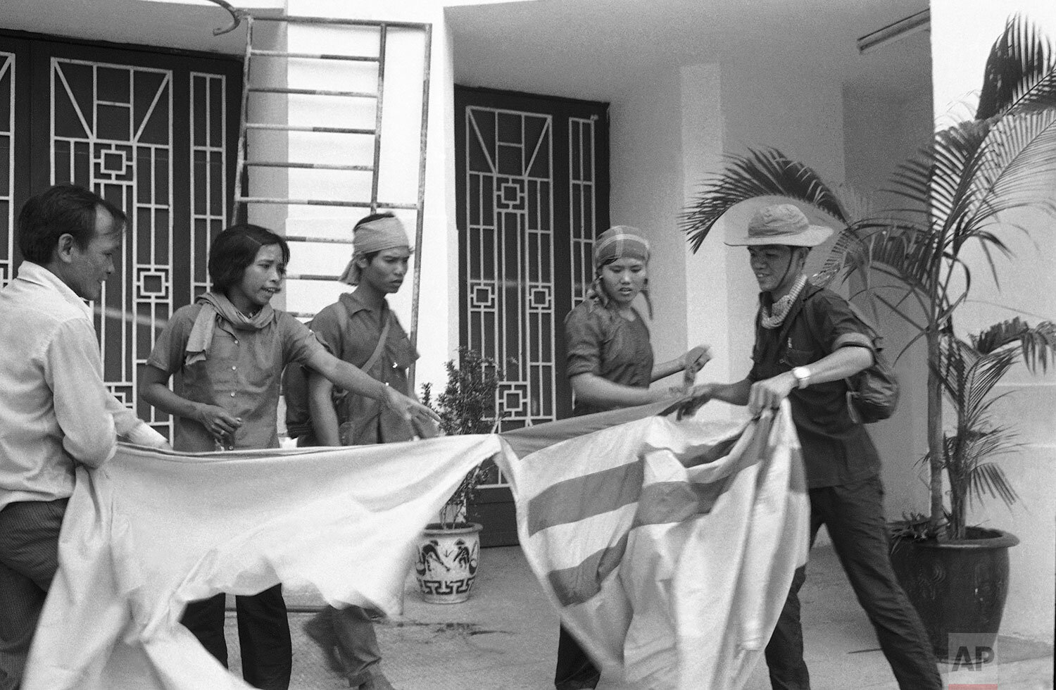  South Viet flag being torn in front of National Assembly Building at Damson Sq. in Saigon on May 4, 1975 by Saigonese and Revolutionary Forces. (AP Photo) 