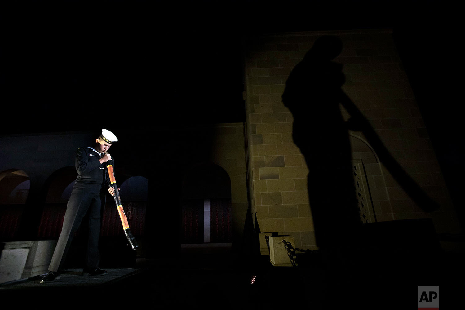  In this photo provided by the Australian War Memorial, Seaman Lynton Robbins of the Royal Australian Navy, plays the didgeridoo during Anzac Day Commemorative Service at the Australian War Memorial in Canberra Saturday, April 25, 2020. (Sean Davey/A