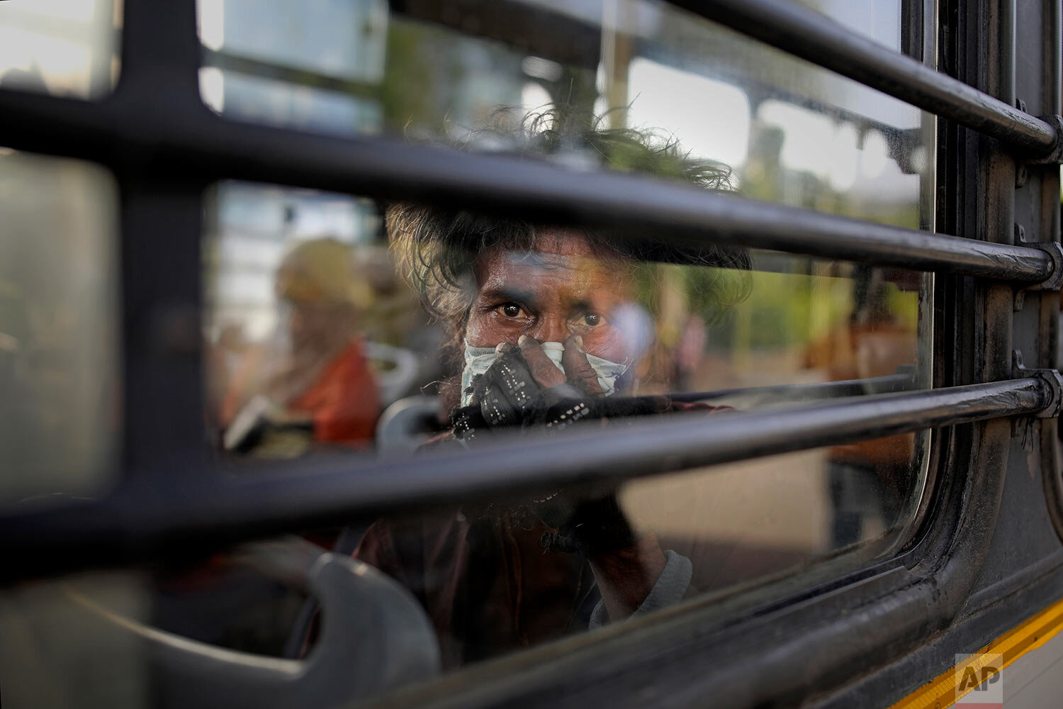  An Indian homeless man sits in a bus as he is being evicted with other homeless people and migrant laborers from the banks of Yamuna River where they have been squatting during lockdown in New Delhi, India, Wednesday, April 15, 2020. (AP Photo/Altaf