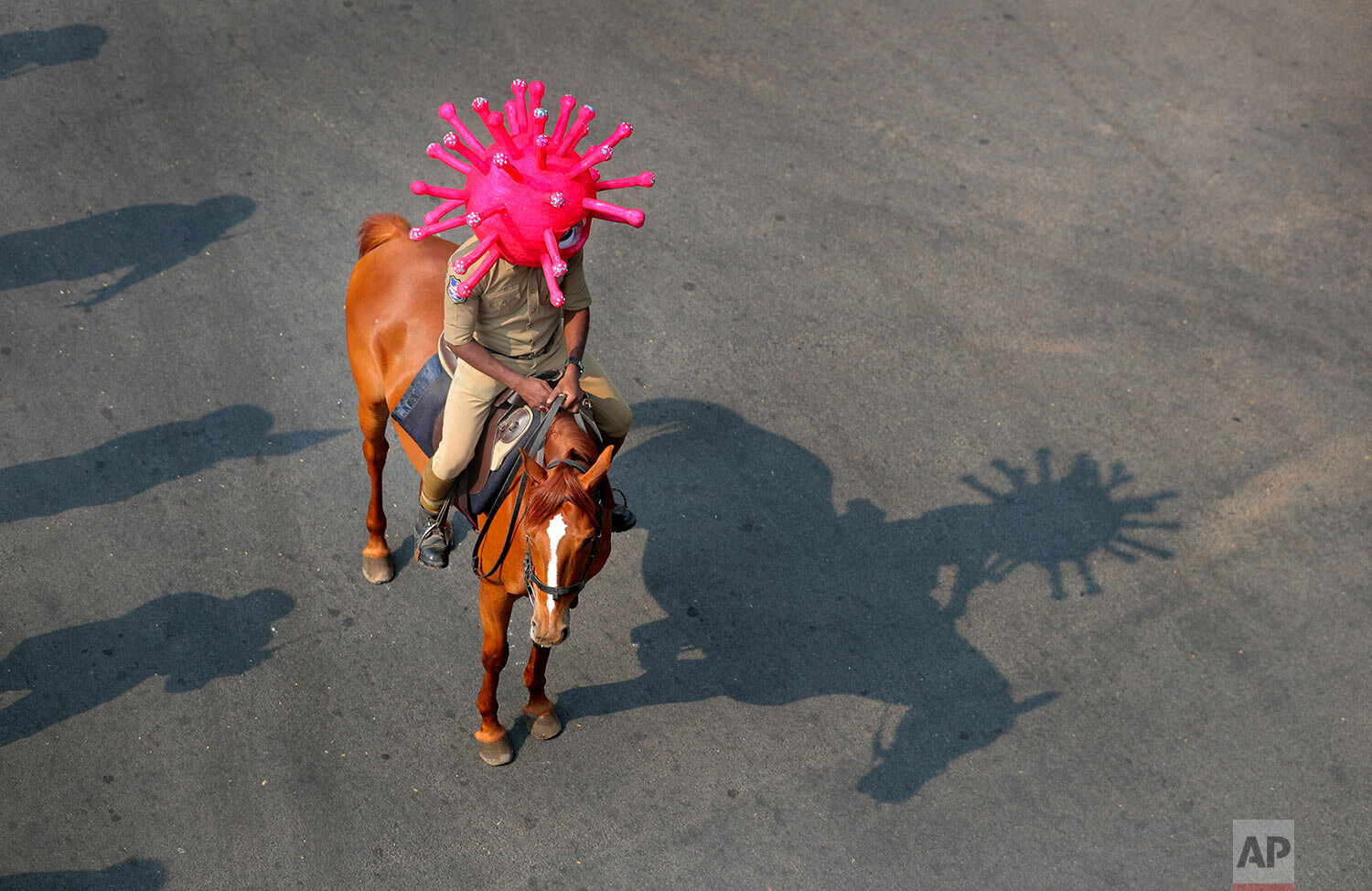  An Indian policeman wearing a virus themed helmet rides on a horse during an awareness rally aimed at preventing the spread of new coronavirus in Hyderabad, India, Thursday, April 2, 2020.  (AP Photo/Mahesh Kumar A.) 