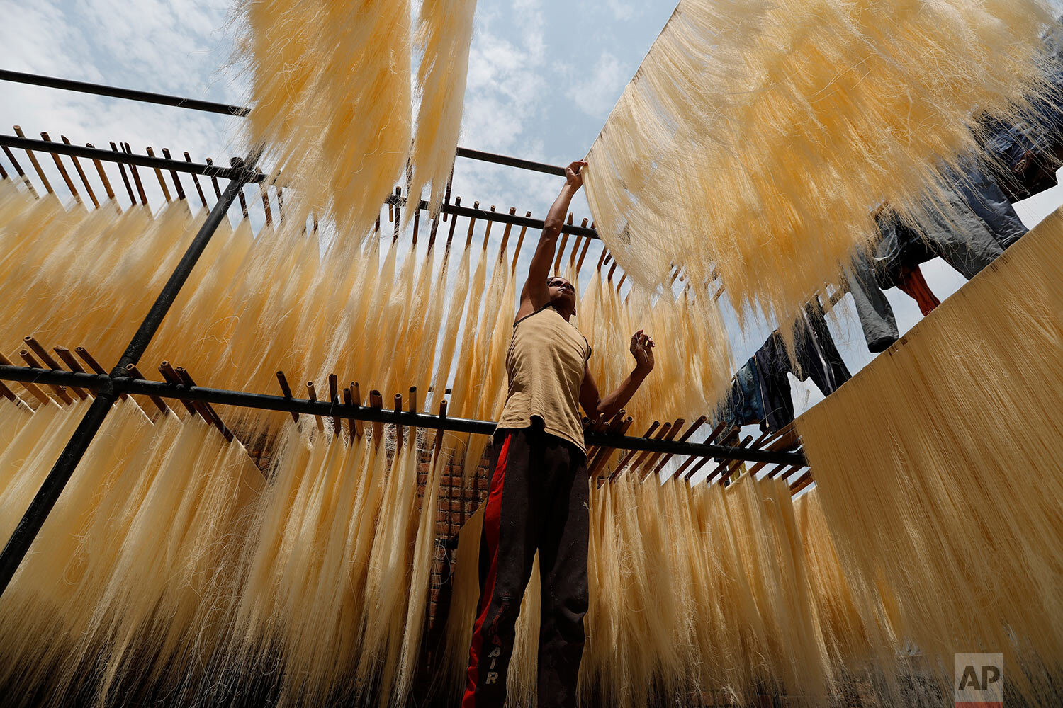  An Indian worker hangs strands of vermicelli to dry at a factory in Prayagraj, India, Saturday, April 25, 2020.  (AP Photo/Rajesh Kumar Singh) 