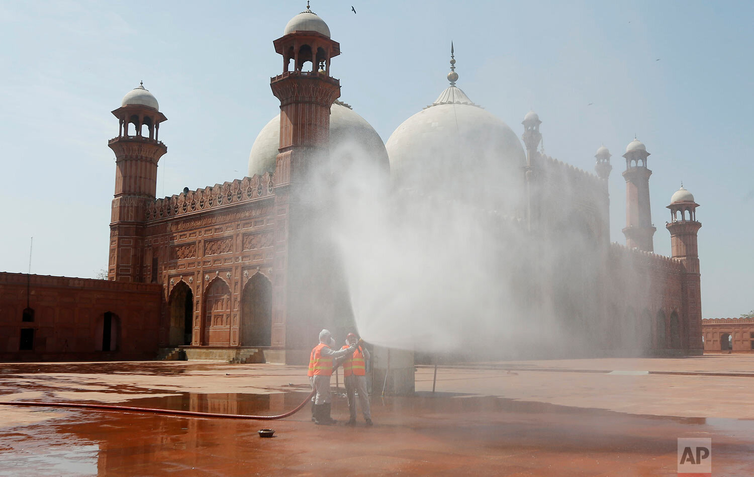  Volunteers disinfect the historical Badshahi Mosque ahead of the Muslim fasting month of Ramadan, in Lahore, Pakistan, Wednesday, April 22, 2020.  (AP Photo/K.M. Chaudhry) 