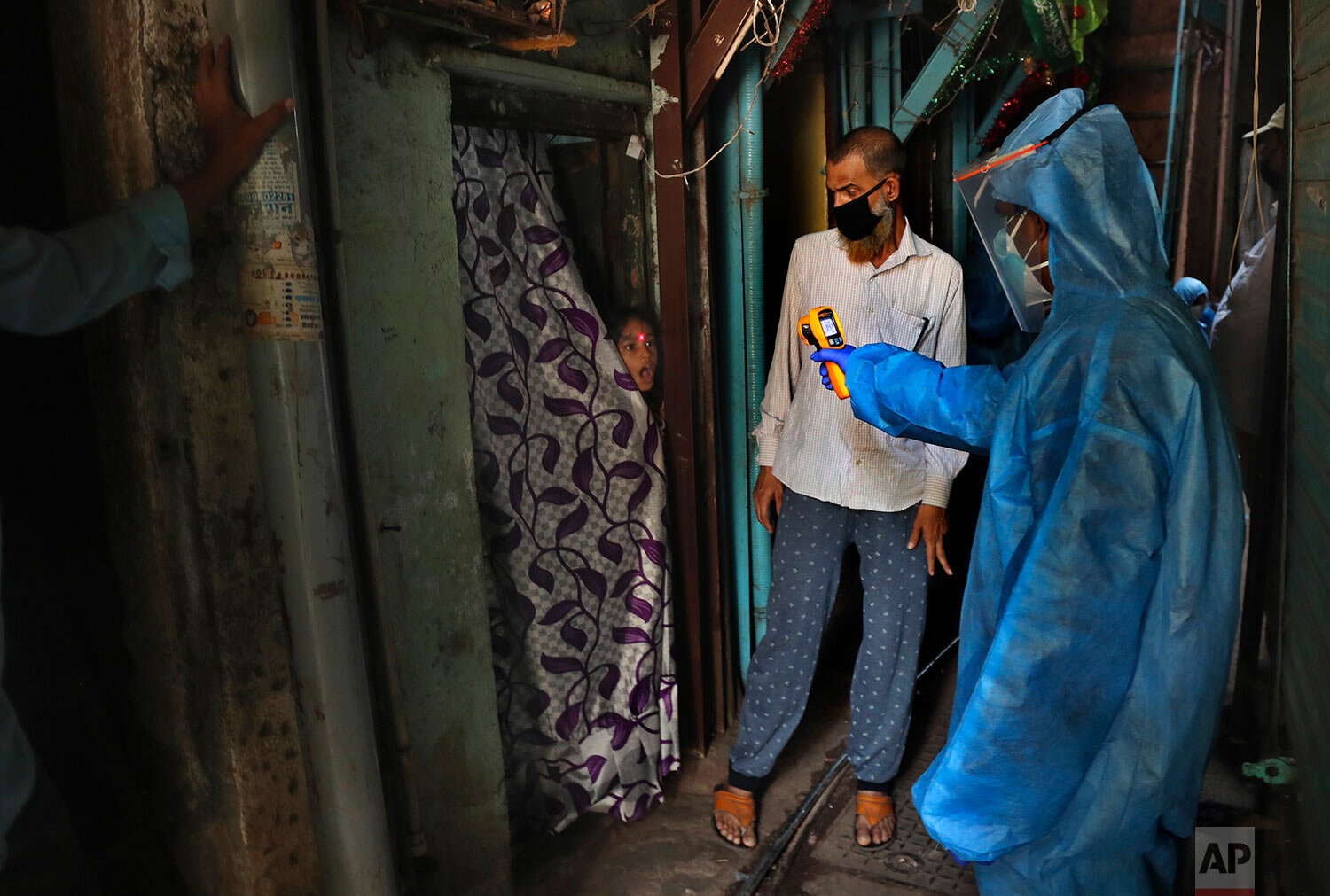  A doctor checks the temperature of a girl in Dharavi, one of Asia's largest slums, during lockdown to prevent the spread of the new coronavirus in Mumbai, India, Monday, April 13, 2020.  (AP Photo/Rafiq Maqbool) 