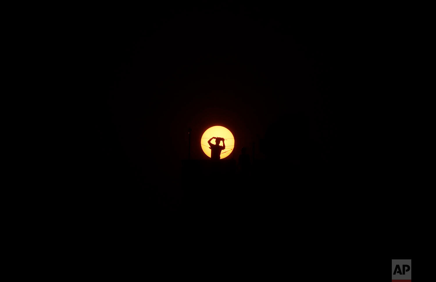  A Nepalese man flying kite standing on the roof top of his house is silhouetted against the setting sun during lockdown in Kathmandu, Nepal, Monday, April 6, 2020. (AP Photo/Niranjan Shrestha) 