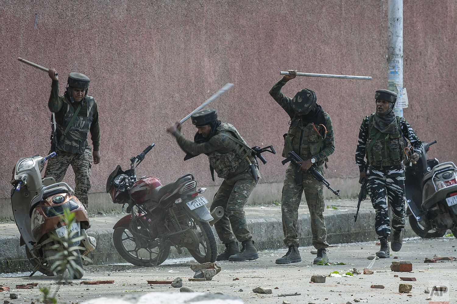  Indian paramilitary soldiers break motorbikes parked outside a college as they clash with students protesting against the alleged rape of a 3-year-old girl in Srinagar, Indian controlled Kashmir, May 14, 2019. (AP Photo/Dar Yasin) 