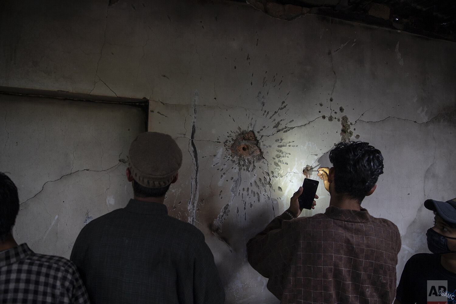  A Kashmiri boy tries to take out a bullet from the wall of a damaged house after a gunbattle in Tral, south of Srinagar, Indian controlled Kashmir, May 24, 2019. (AP Photo/Dar Yasin) 