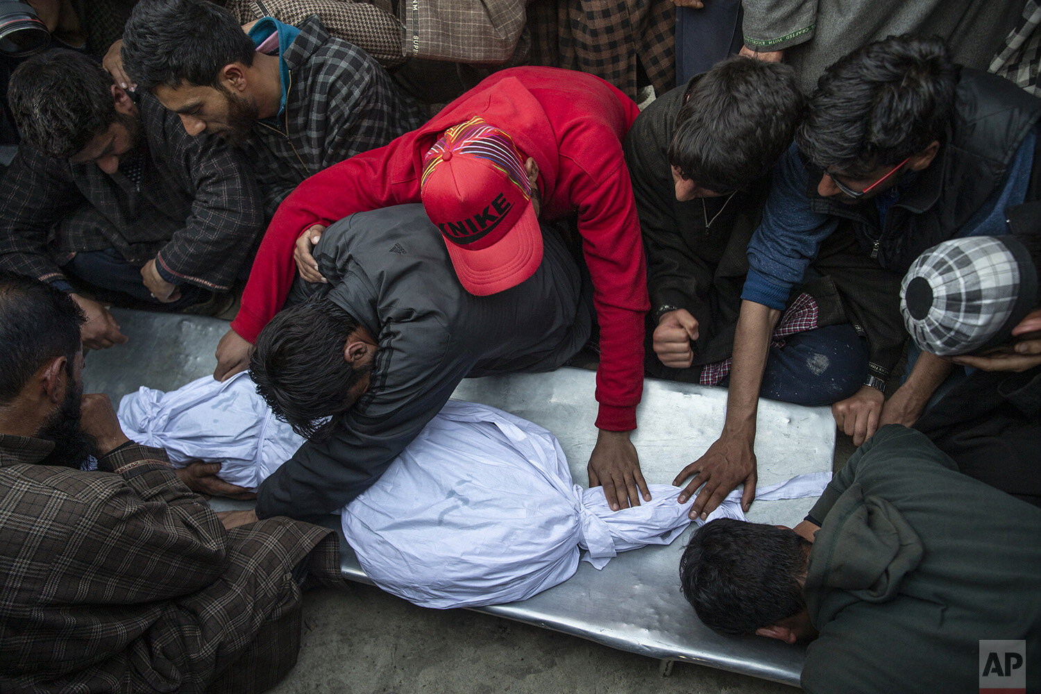  Kashmiri villagers grieve near the body of an 11-year-old boy, Aatif Mir, during his funeral procession in Hajin village, north of Srinagar Indian controlled Kashmir, March 22, 2019. Indian security forces killed five militants and the 11-year-old h