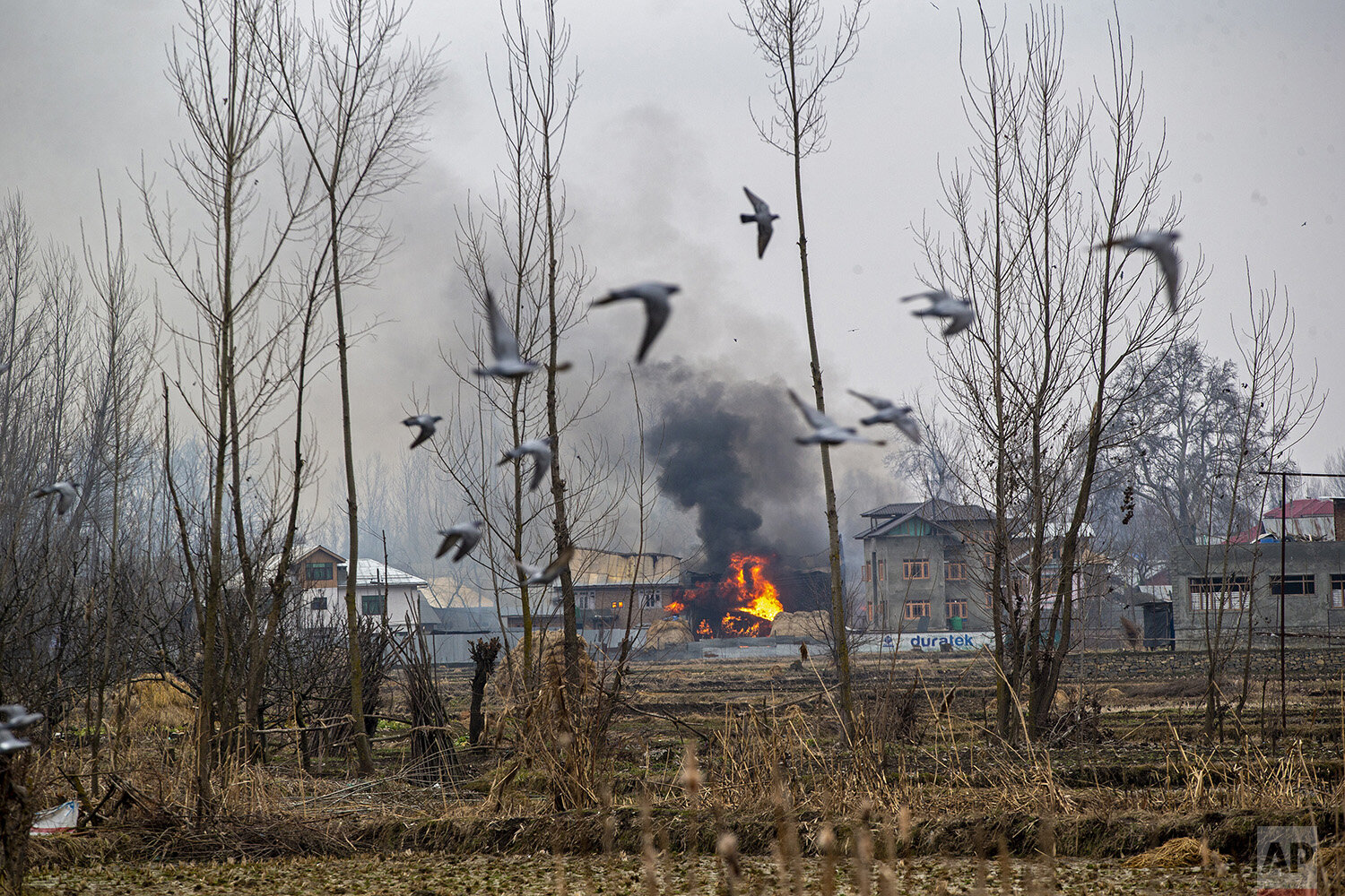  Flames and smoke billow from a residential building where militants are suspected to have taken refuge during a gun battle in Pulwama, south of Srinagar, Indian controlled Kashmir, Feb. 18, 2019. (AP Photo/Dar Yasin) 