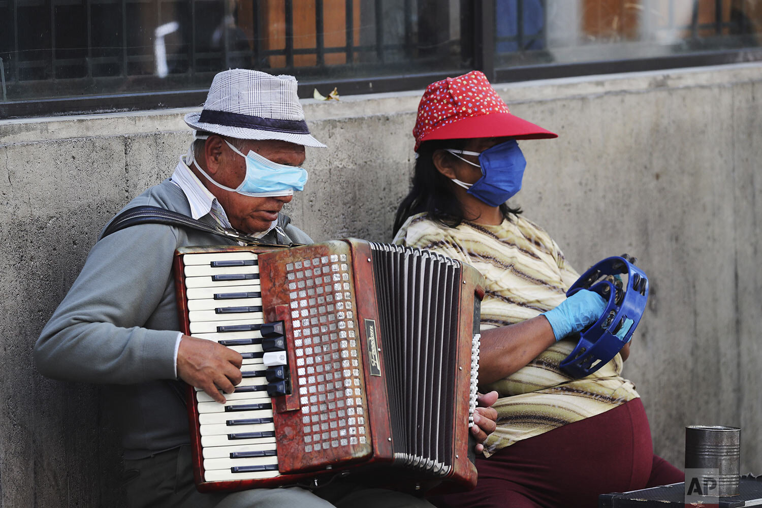  A blind man and his musical partner wear masks to prevent the spread of the new coronavirus as they play for tips in downtown Quito, Ecuador, Friday, April 3, 2020. (AP Photo/Dolores Ochoa) 