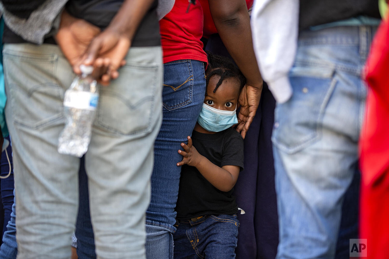  A child looks at the camera as Haitians who were deported from the U.S. line up at a hotel where they will be quarantined as a measure against the spread of the new coronavirus in Tabarre, Haiti, Thursday, April 23, 2020. (AP Photo/Dieu Nalio Chery)