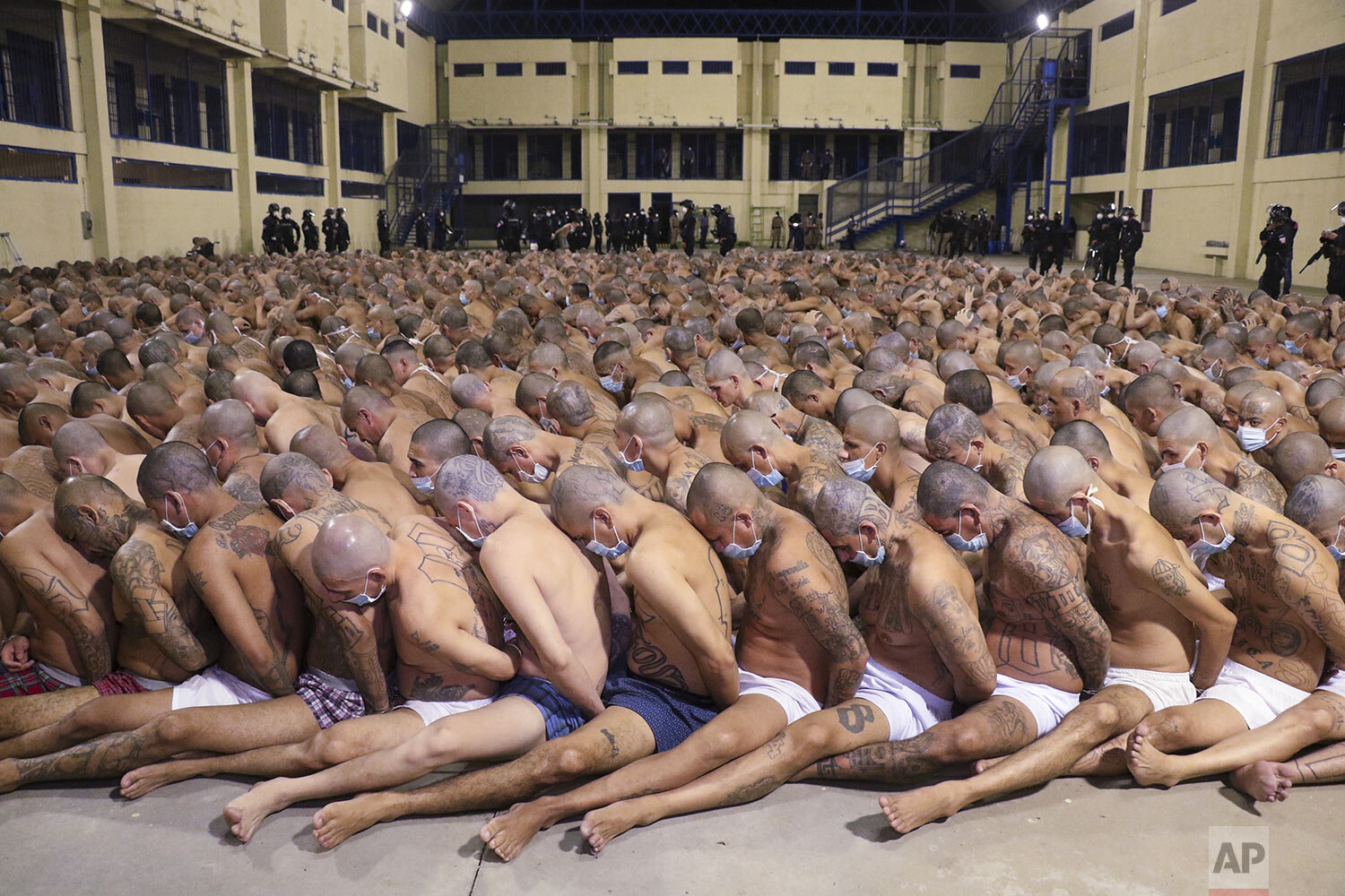  This photo released by the El Salvador presidencial press office shows inmates lined up during a security operation to search their cells, under the watch of police at the Izalco prison in San Salvador, El Salvador, Saturday, April 25, 2020. (El Sal