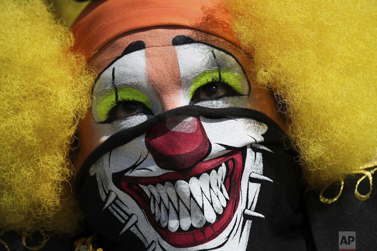  A clown wearing a decorative face mask as a precaution amid the spread of the new coronavirus protests with other clowns against restrictions keeping them from working in the streets of Mexico City, Thursday, April 30, 2020. (AP Photo/Fernando Llano