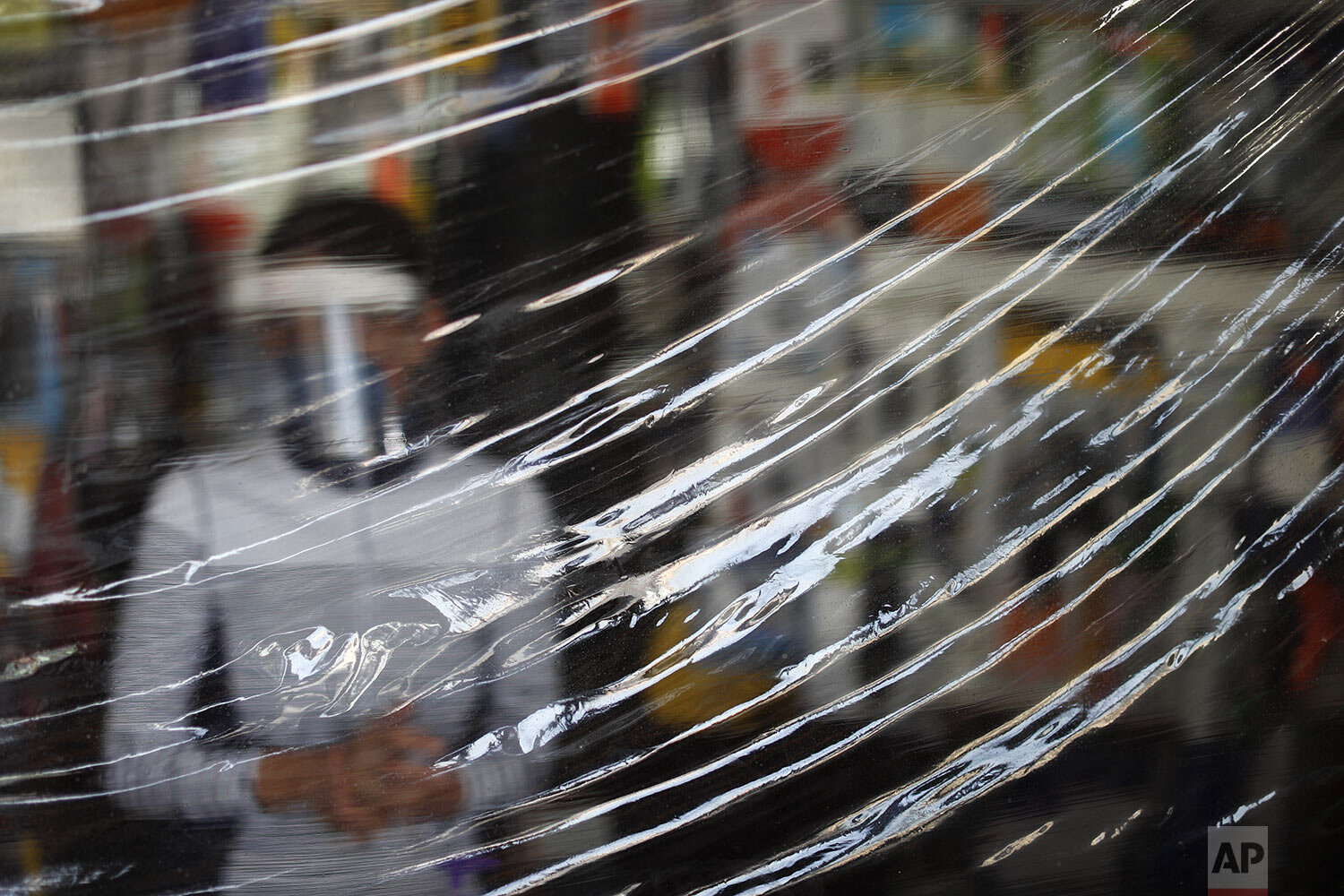  Carmen Castellanos, 54, wears a face mask and shield behind a protective sheet of plastic hanging over the counter, at El Foquito, a hardware and electric supply store she owns with her brother in Mexico City, Wednesday, April 15, 2020. The Castella