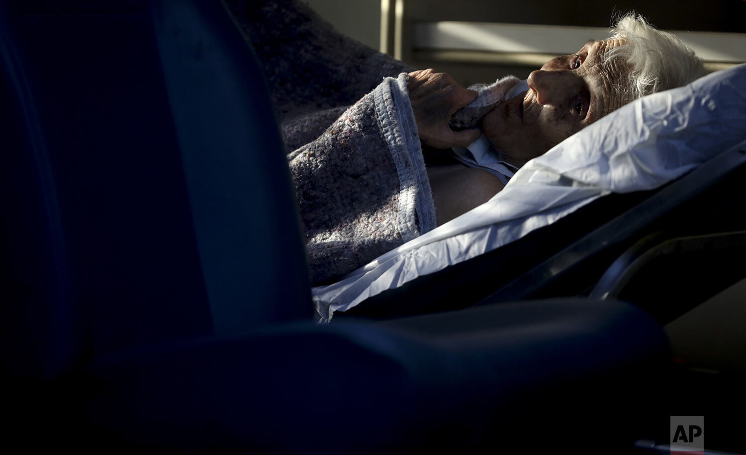  An elderly woman lies inside an ambulance while evacuated from a nursing home where multiple residents tested positive for the new coronavirus in Buenos Aires, Argentina, Wednesday, April 22, 2020. (AP Photo/Natacha Pisarenko) 