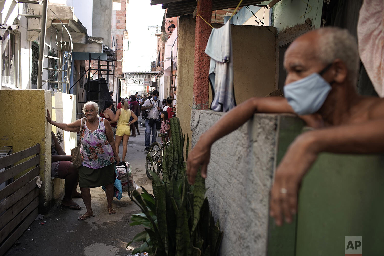  An elderly woman pulls a grocery caddy filled with food donated by a non-governmental agency amid the the new coronavirus pandemic, in the Mandela favela, in Rio de Janeiro, Brazil, April 21, 2020. (AP Photo/Silvia Izquierdo) 