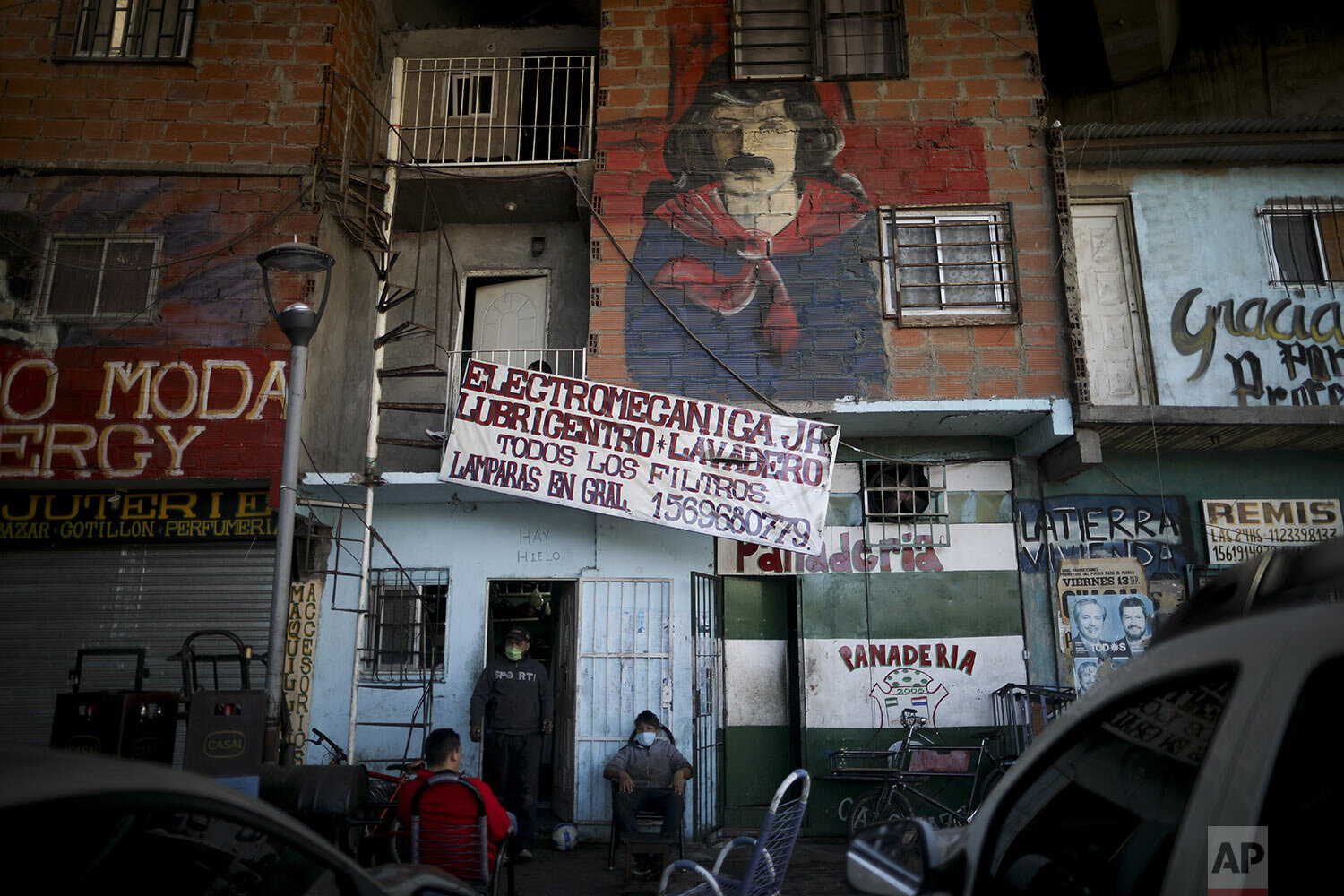  Residents talk outside a shop in “Villa 31” in Buenos Aires, Argentina, Thursday, April 30, 2020. (AP Photo/Natacha Pisarenko) 