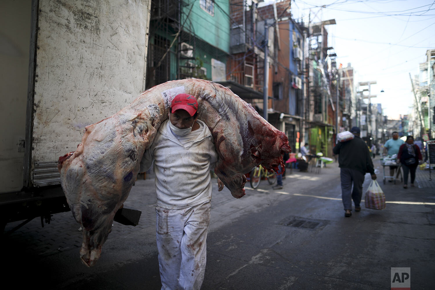  A worker delivers a carcass of beef in “Villa 31” in Buenos Aires, Argentina, Thursday, April 30, 2020. (AP Photo/Natacha Pisarenko) 