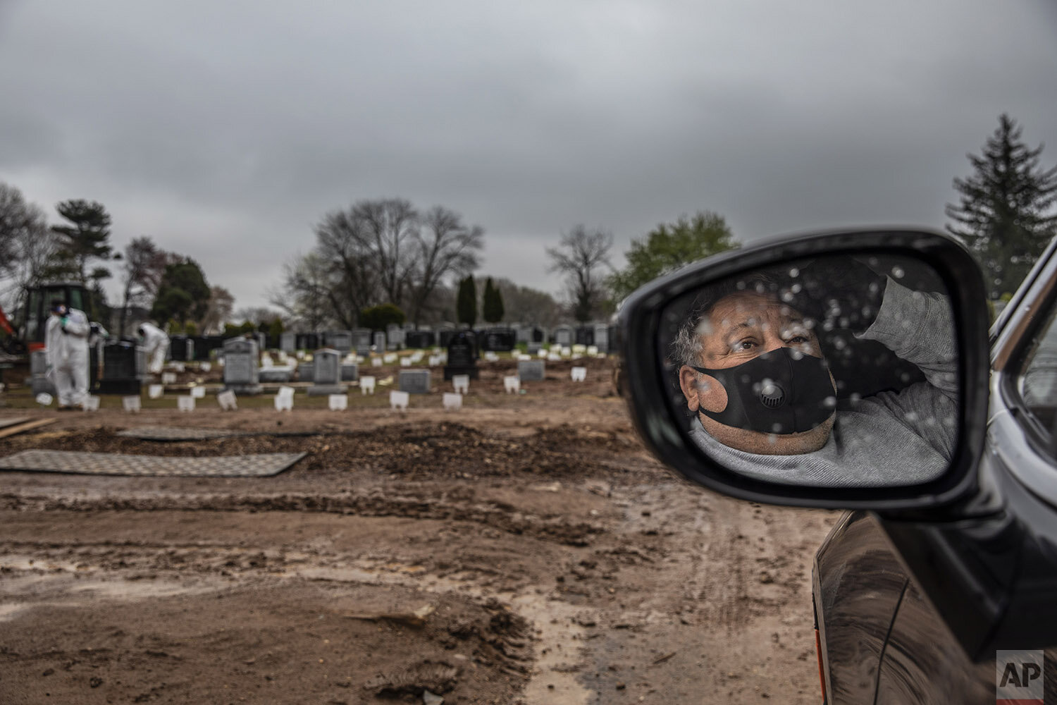  Michael Tokar observes from his car as his father, David Tokar, is buried at Mount Richmond Cemetery in the Staten Island borough of New York, Wednesday, April 8, 2020. Tokar???s father had a cough and fever and a home health aide got him to the hos