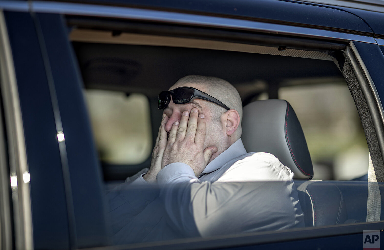 Jason Boxer wipes away tears while observing from the car the burial of his father, Allen Boxer, at Mount Richmond Cemetery in the Staten Island borough of New York, Sunday, April 12, 2020. "He was kind and gentle and had the biggest heart of anyone