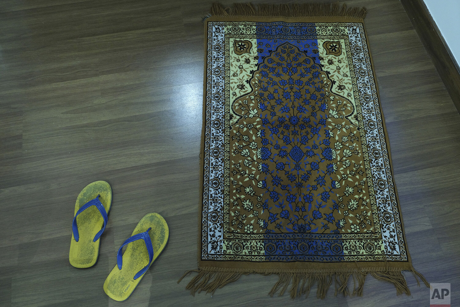  In this photo taken on April 24, 2020, photo, a pair of sandals lie near a prayer mat in the hotel room of Associated Press photographer Rafiq Maqbool, where he was being quarantined, in Mumbai, India. Maqbool was tested positive for COVID-19 with d