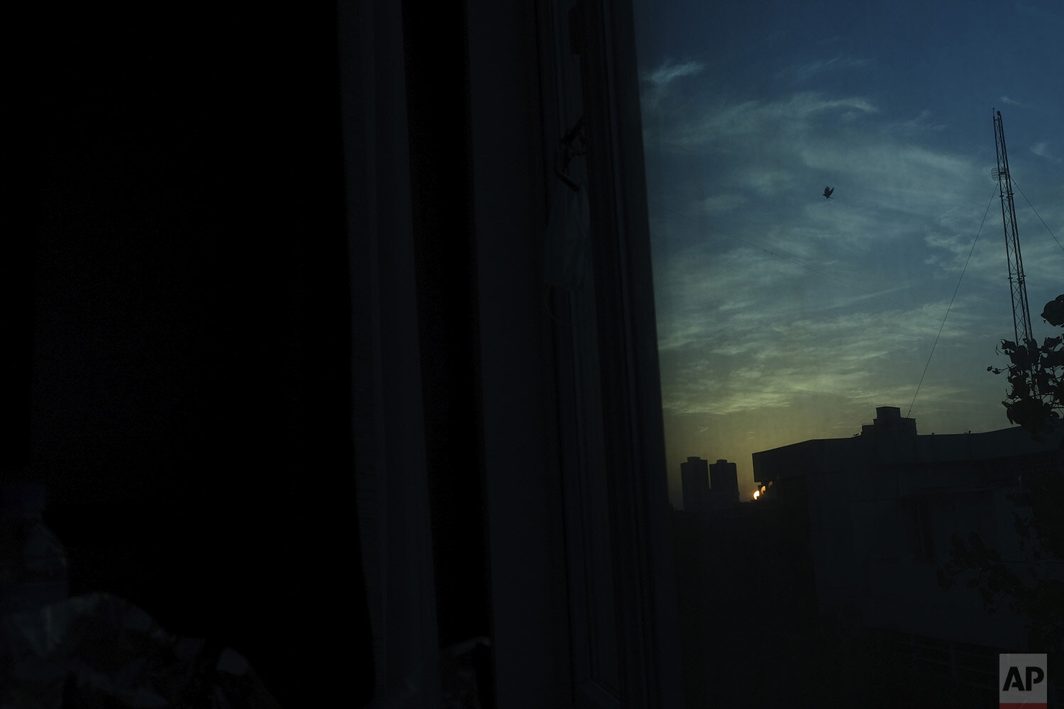  In this April 23, 2020, photo, a bird flies at sunset as seen from the hotel room of Associated Press photographer Rafiq Maqbool, where he has been quarantined, in Mumbai, India. Maqbool was among dozens of journalists who tested positive for COVID-