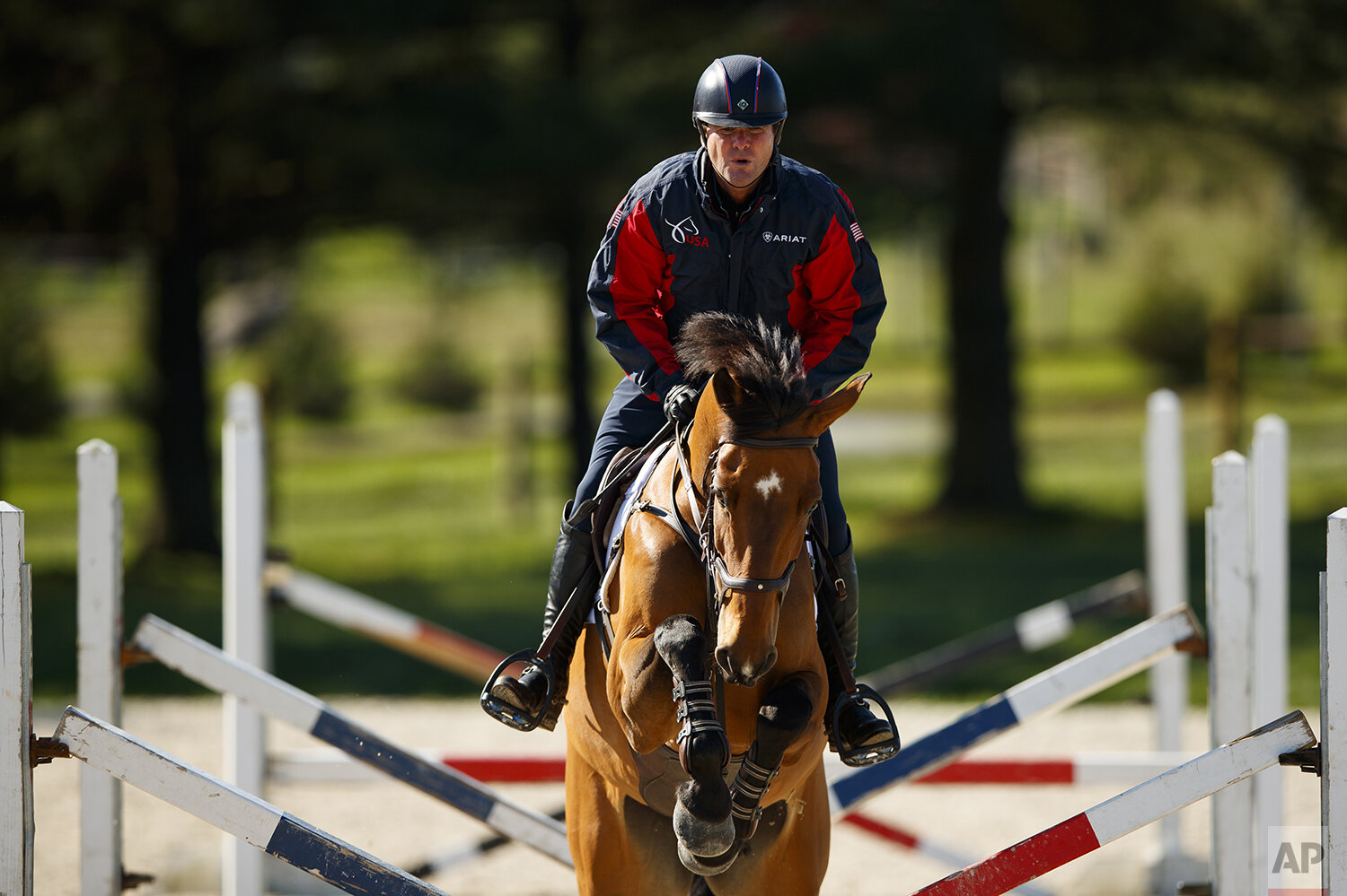  Phillip Dutton, a medal-winning equestrian on the U.S. Olympic team, rides Z, through a series of jumps while training at his farm, Thursday, April 2, 2020, in West Grove, Pa. (AP Photo/Matt Slocum) 