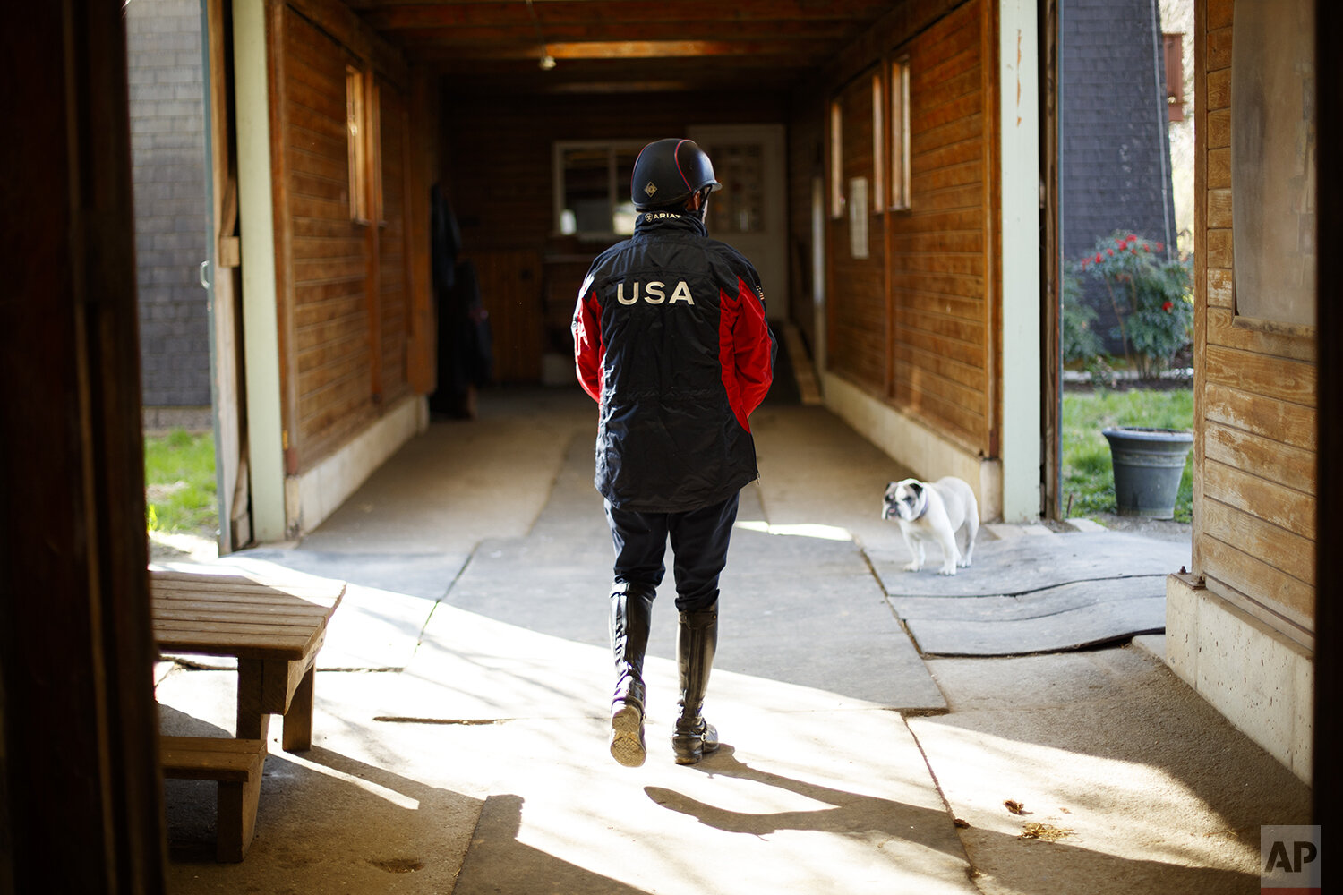  Phillip Dutton, a medal-winning equestrian on the U.S. Olympic team, walks through the barn at his farm before a training session, Thursday, April 2, 2020, in West Grove, Pa. (AP Photo/Matt Slocum) 