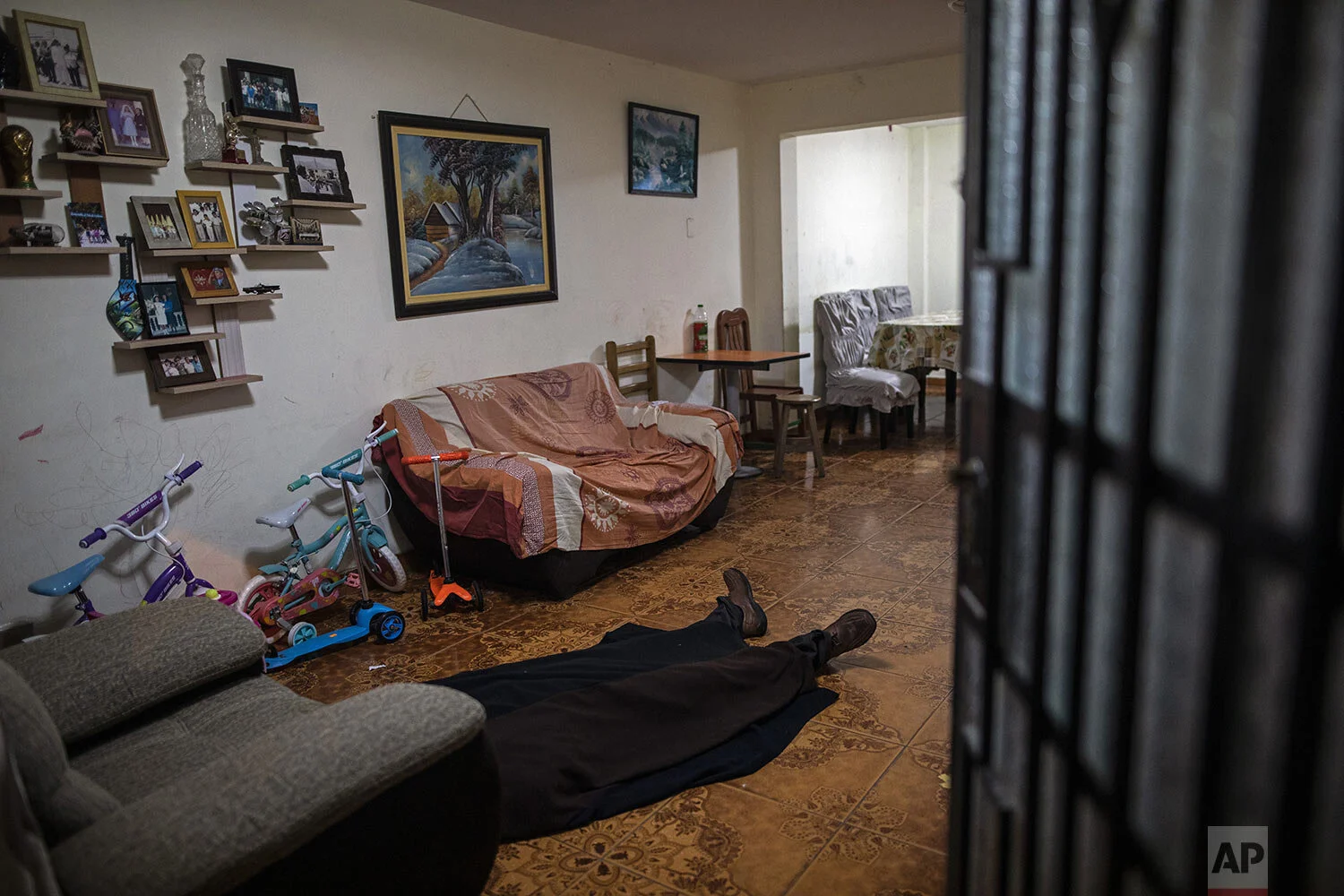  The body of Ricardo Noriega, suspected of dying from the new coronavirus, lies covered by a blanket on his living room floor in Lima, Peru, Monday, May 4, 2020. The 77-year-old clothing salesman felt ill in late April and couldn't find a taxi or a r