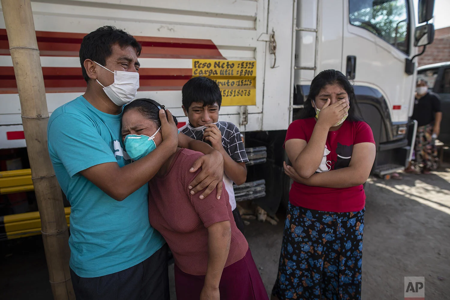  Family members grieve as they watch Piedrangel funeral home workers remove the body of a relative suspected of dying from the new coronavirus, in Lima, Peru, Monday, May 11, 2020. (AP Photo/Rodrigo Abd) 