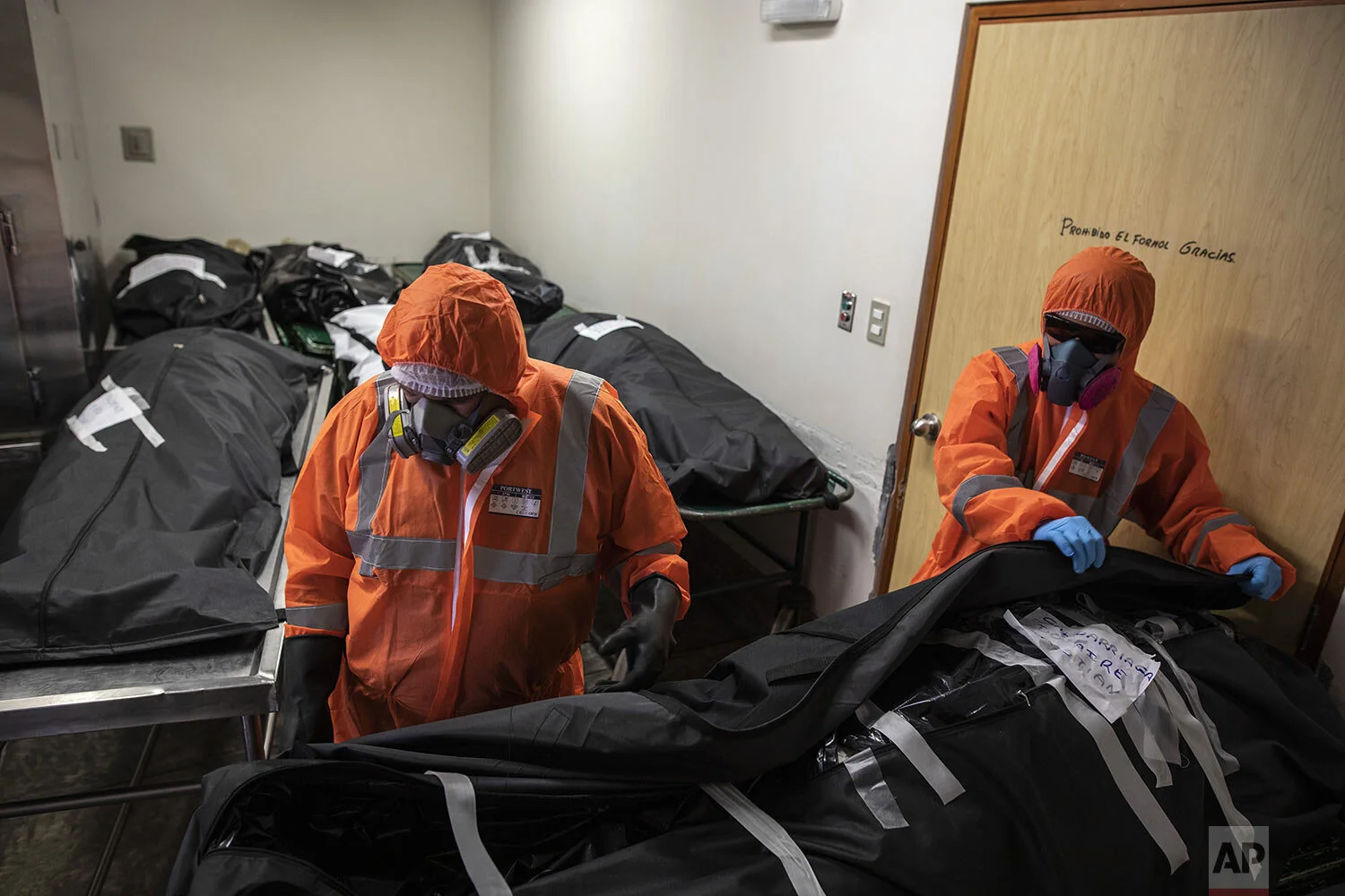  Piedrangel funeral home workers, Luis Zerpa of Venezuela and Peruvian Angelo Aza, prepare to remove bodies of deceased persons who are suspected to have died from the new coronavirus, from a public hospital morgue in Lima, Peru, Tuesday, May 5, 2020