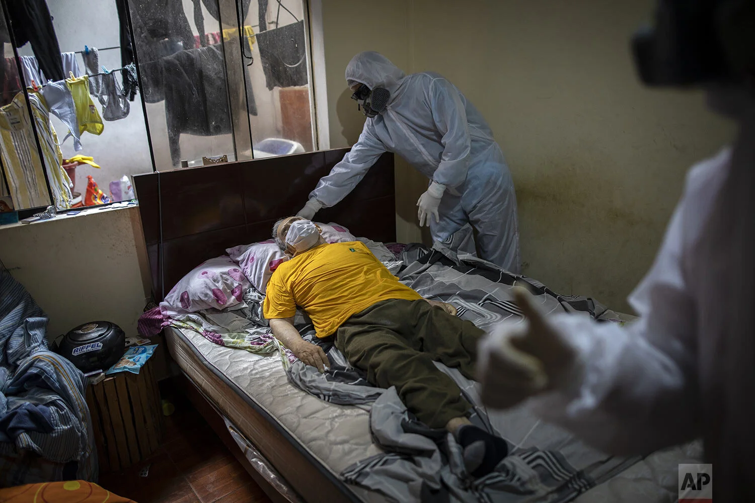  Piedrangel funeral home workers prepare to remove the body of a man suspected to have died from the new coronavirus, from his home in Lima, Peru, May 15, 2020. (AP Photo/Rodrigo Abd) 