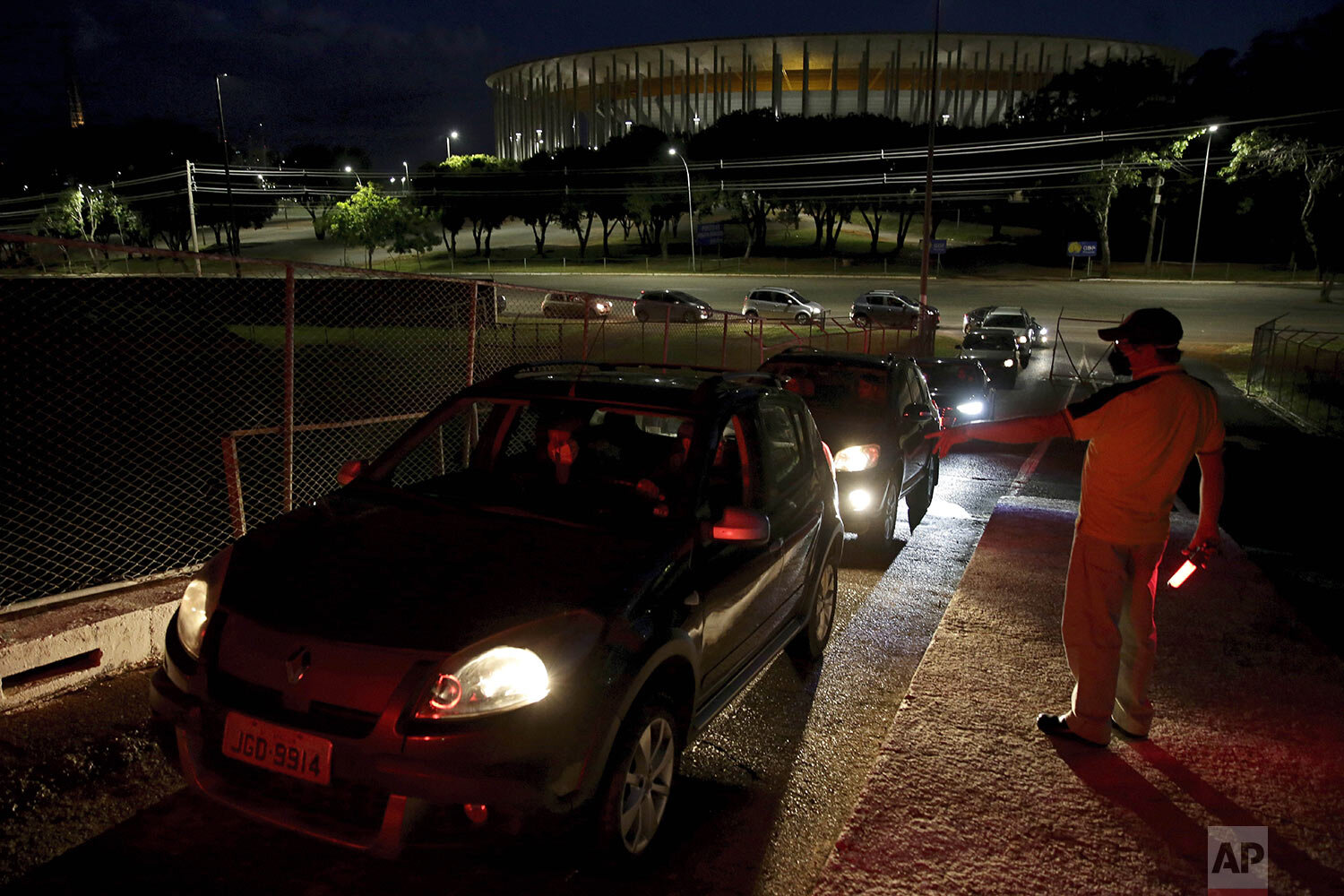 Jair de Souza speaks to drivers arriving at a drive-in movie theater, amid the new coronavirus pandemic in Brasilia, Brazil, Wednesday, May 13, 2020. (AP Photo/Eraldo Peres) 