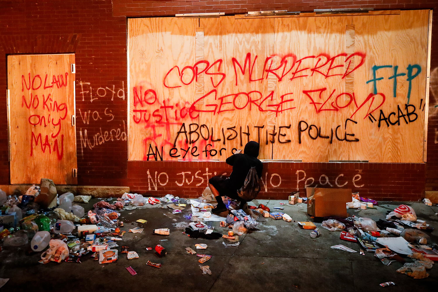  A protestor sprays graffiti on a wall near the Minneapolis 3rd Police Precinct, Thursday, May 28, 2020, in Minneapolis. (AP Photo/John Minchillo) 