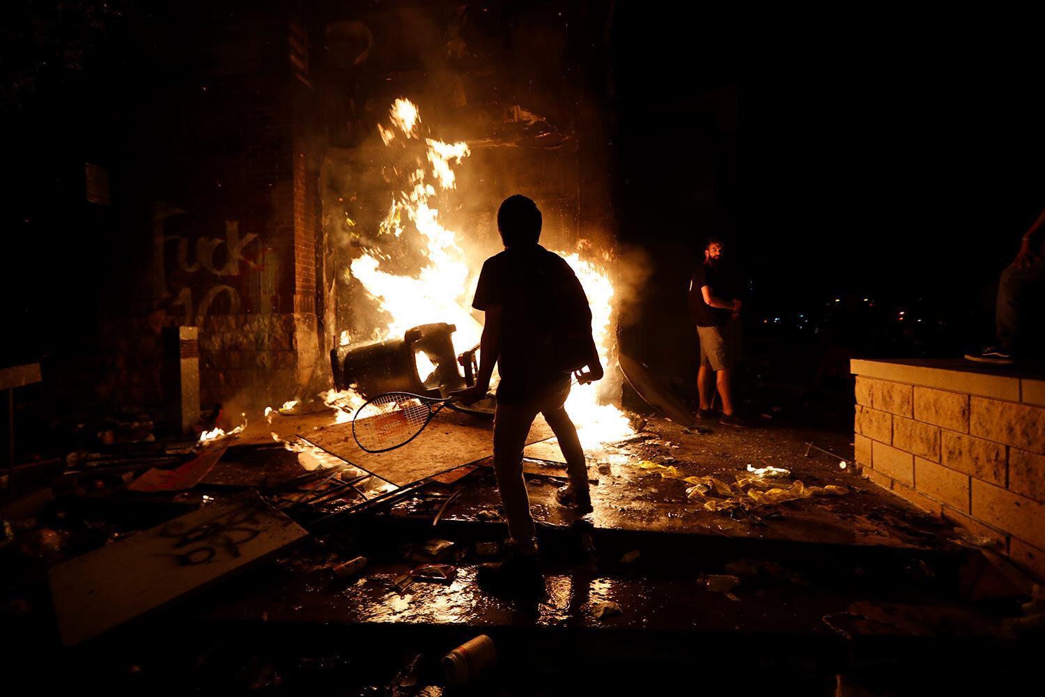  EDS NOTE: OBSCENITY - Protesters add fuel to a fire at the Minneapolis police 3rd Precinct building Thursday, May 28, 2020, in Minneapolis. Violent protests over the death of George Floyd, a black man who died in police custody Monday, broke out in 