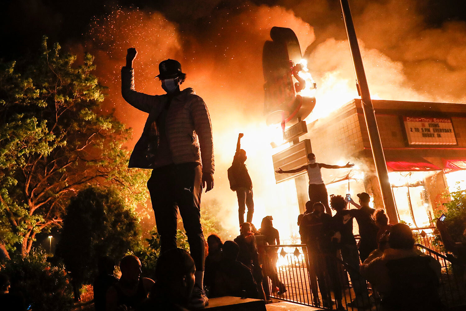  Protestors demonstrate outside of a burning fast food restaurant, Friday, May 29, 2020, in Minneapolis. (AP Photo/John Minchillo) 