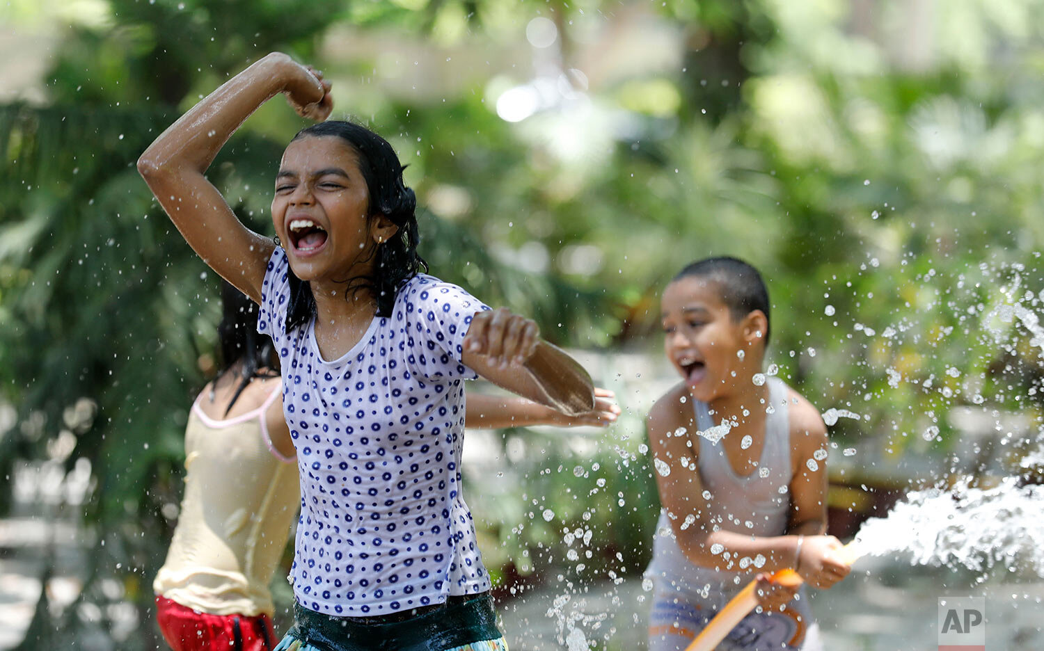  Children cool off with water splashing from a pipe on a hot summer day in Fatehpur, India, Sunday, May 17, 2020. (AP Photo/Rajesh Kumar Singh) 