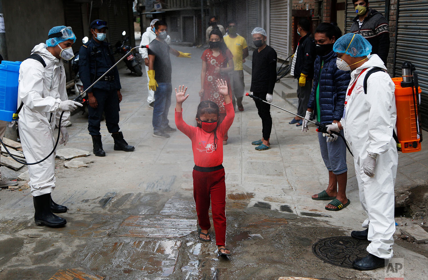  A young Nepalese girl is sprayed with disinfectants as she arrives to get free food distributed by social workers during a lockdown to control the spread of the new coronavirus in Kathmandu, Nepal, Sunday, May 3, 2020. (AP Photo/Niranjan Shrestha) 