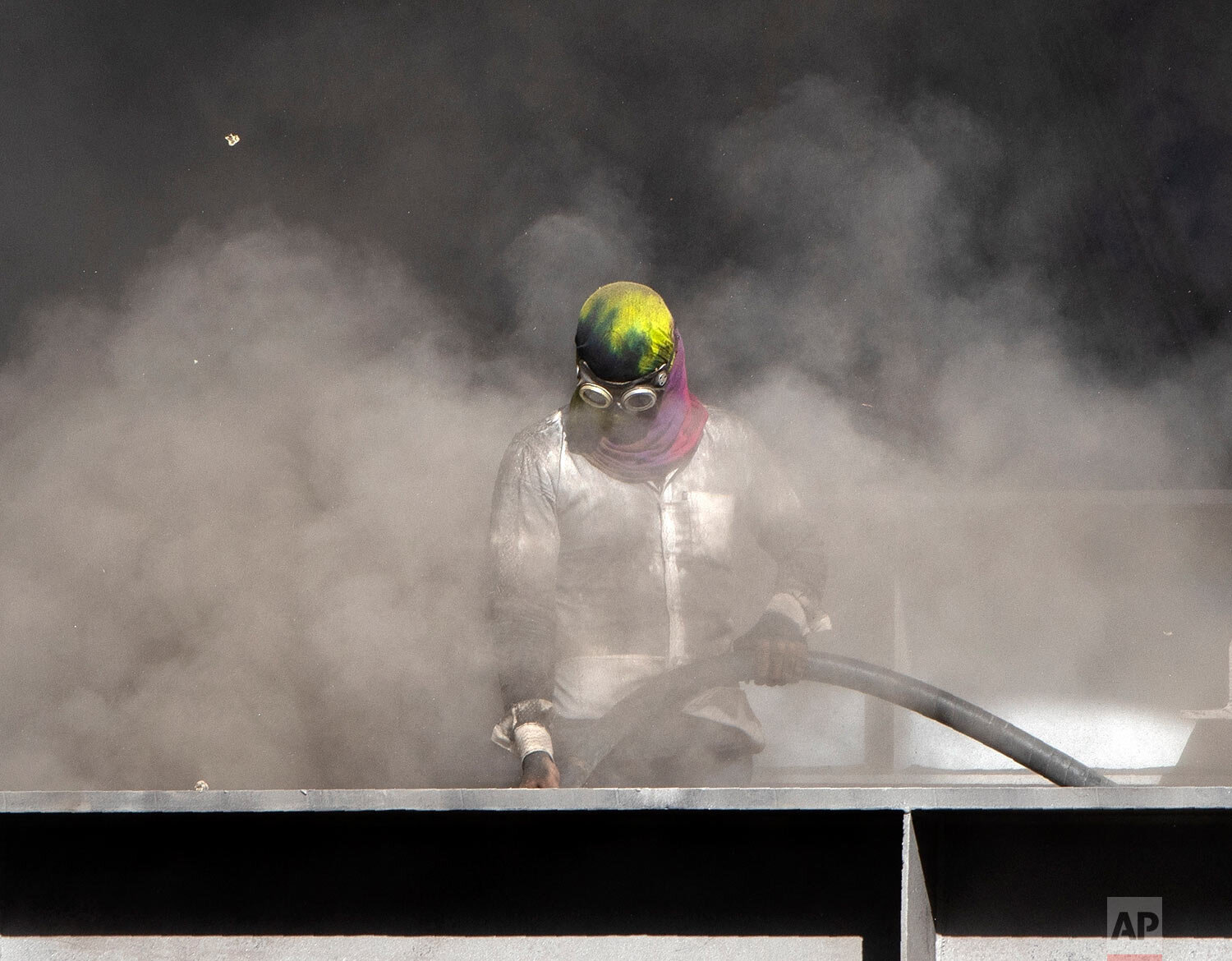  A worker cleans a foot bridge construction site at a train station in Mumbai, India, Monday, May 4, 2020.  (AP Photo/Rajanish Kakade) 