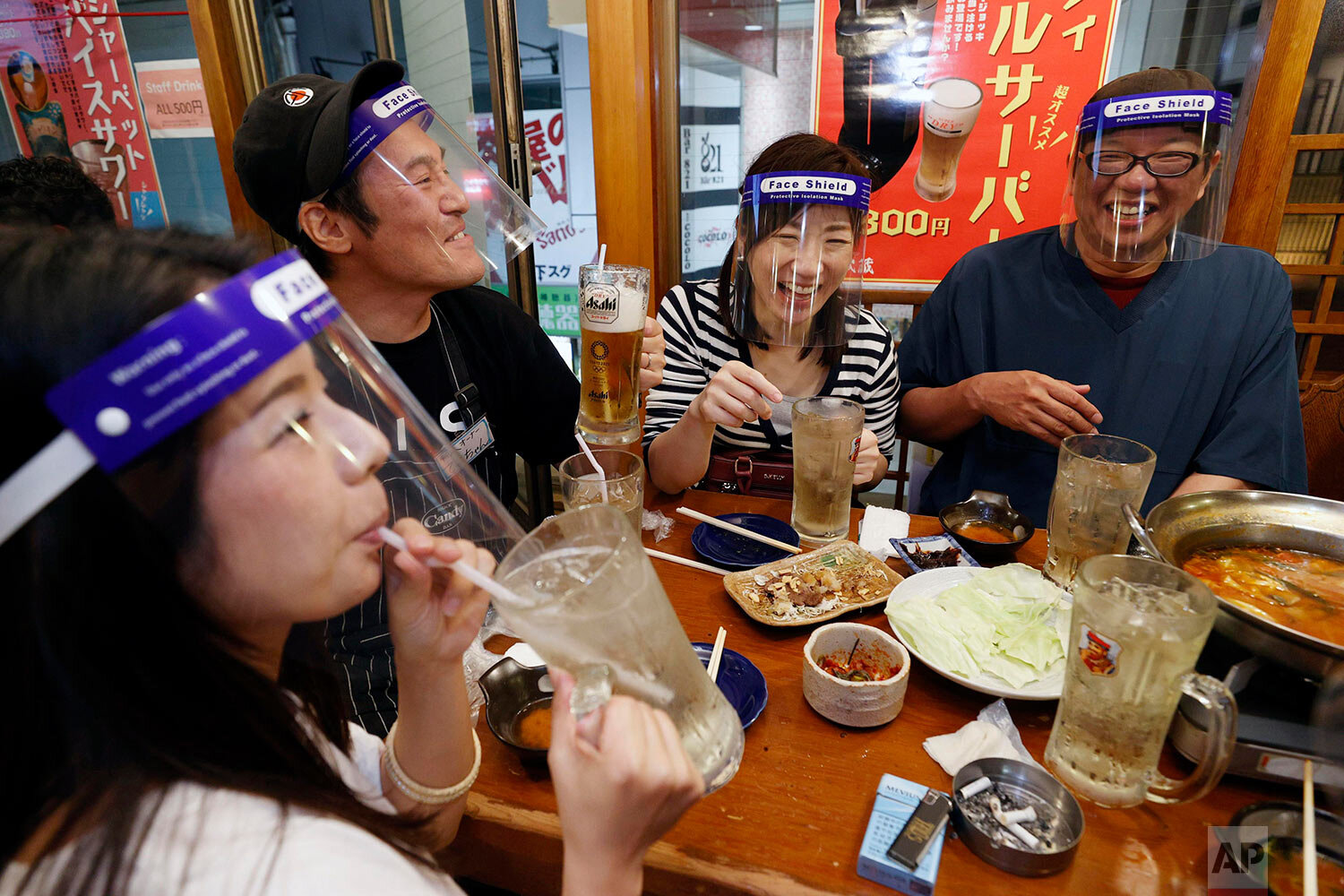  People, wearing face shields, eat together at a pub in Osaka, western Japan Monday, May 25, 2020, as Japan lifted the coronavirus state of emergency in Osaka and the two neighboring prefectures of Kyoto and Hyogo. (Suo Takekuma/Kyodo News via AP) 