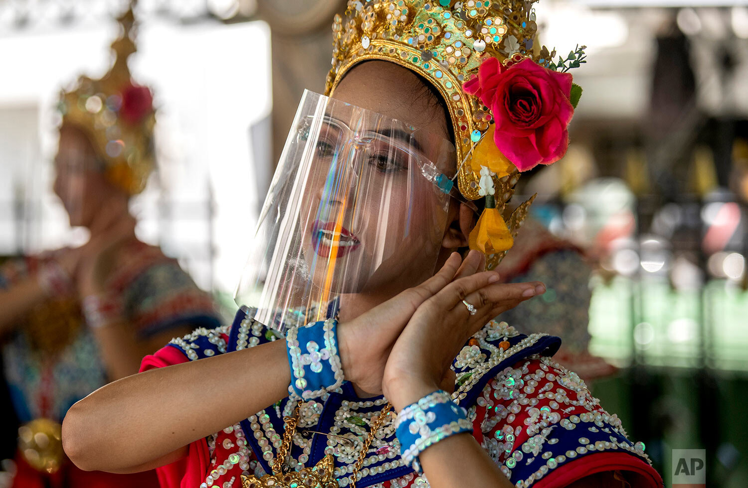  A Thai classical dancer wearing a face shield to help curb the spread of the coronavirus performs at the Erawan Shrine in Bangkok, Thailand, Thursday, May 28, 2020. (AP Photo/Sakchai Lalit) 