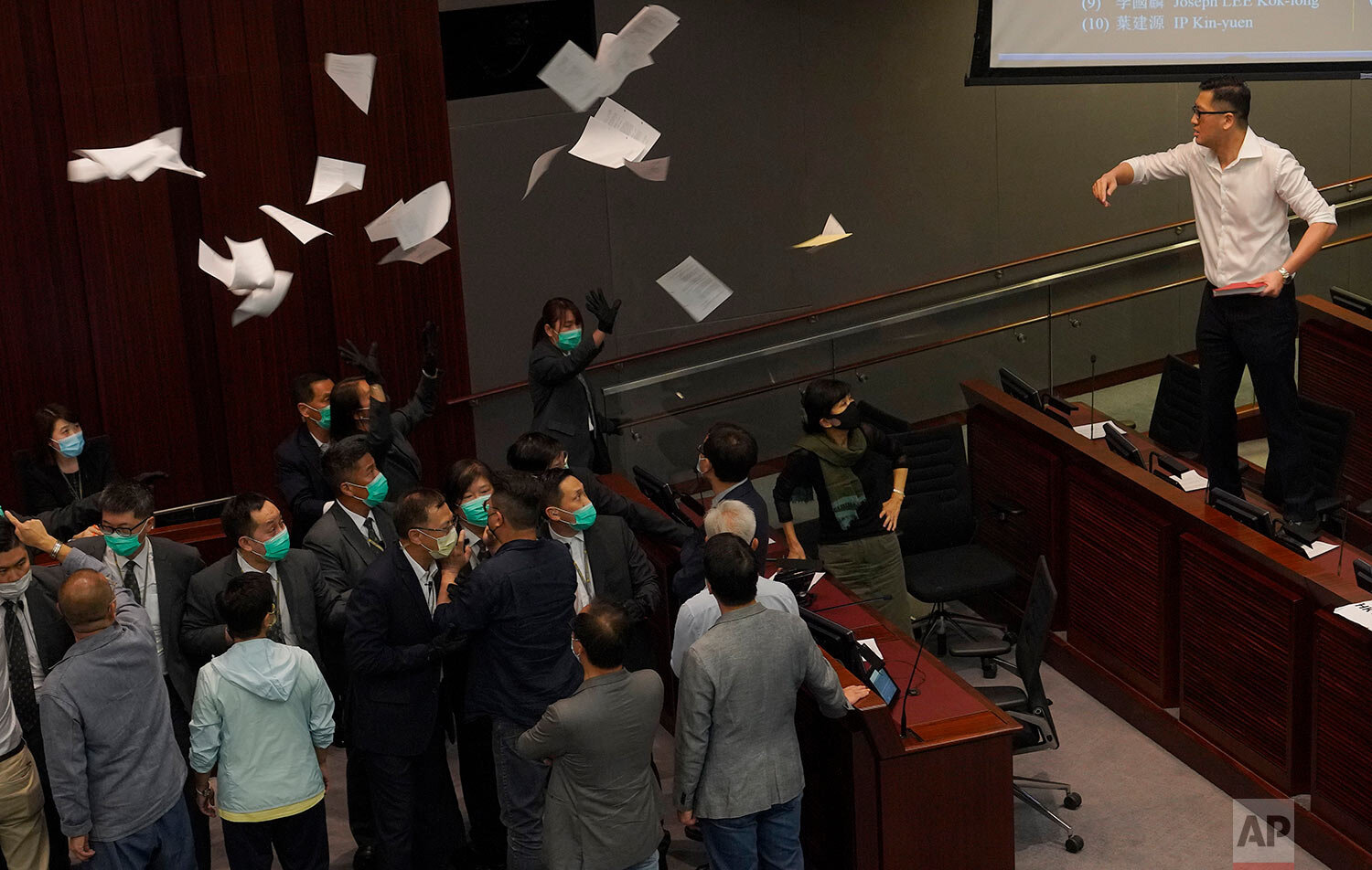  Pan-democratic legislator Lam Cheuk-ting, right, throws papers towards Pro-Beijing politician, Chan Kin-por as they attend a Legislative Council's House Committee meeting in Hong Kong, Monday, May 18, 2020.  (AP Photo/Vincent Yu) 