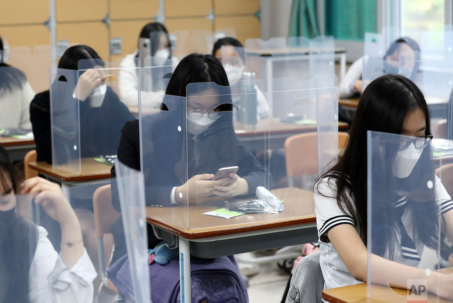  Senior students wait for class to begin with plastic boards placed on their desks at Jeonmin High School in Daejeon, South Korea, Wednesday, May 20, 2020.  (Kim Jun-beom/Yonhap via AP) 