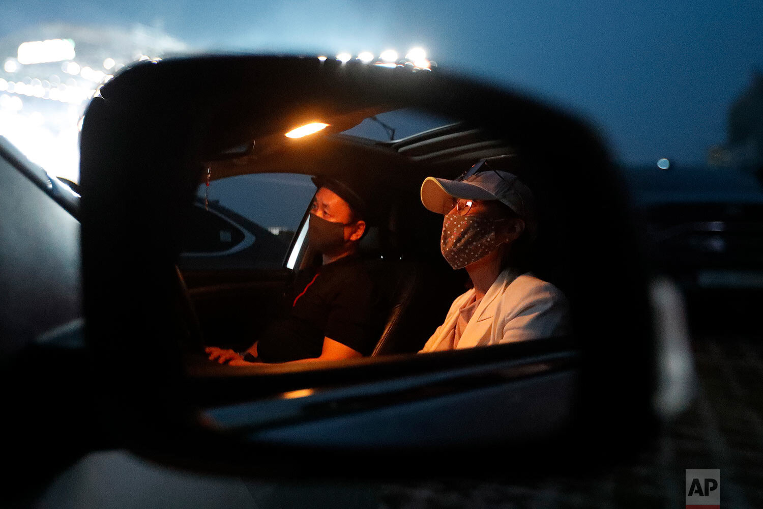 People sit in their car as they watch the Stage X drive-in concert at KINTEX parking lot in Goyang, South Korea, Saturday, May 23, 2020. (AP Photo/Ahn Young-joo) 