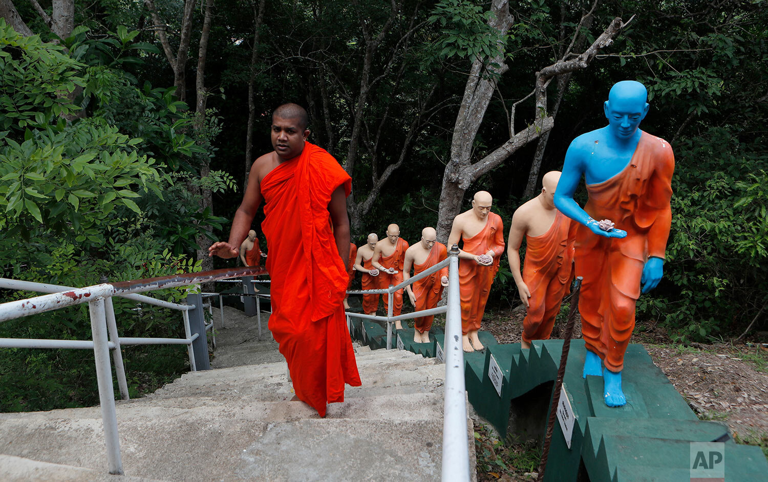  A Sri Lankan Buddhist monk climbs the steps past statues at a deserted temple during curfew on Buddha Jayanthi, a day that celebrates the birth of the Buddha, in Colombo, Sri Lanka, Thursday, May 7, 2020.  (AP Photo/Eranga Jayawardena) 