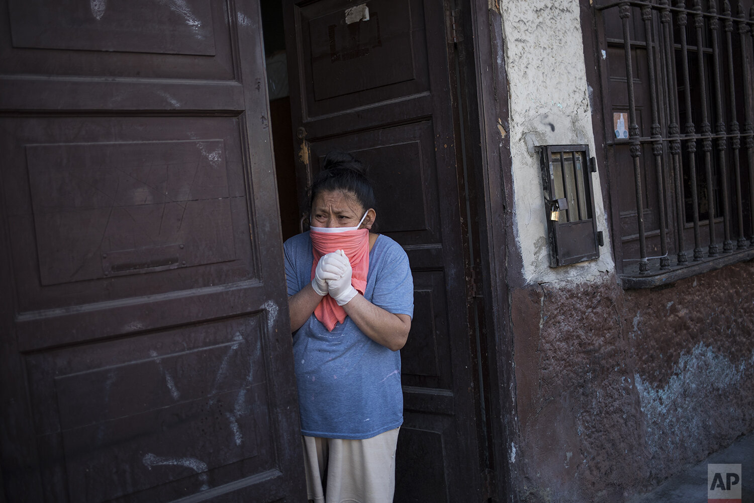  In this May 9, 2020 photo, Palmira Cortez, 65, mourns while looking at funeral home works carrying the corpse of her husband  Walter YarlequÈ, 79, who died allegedly from COVID-19, un Lima, Peru. (AP Photo/Rodrigo Abd) 